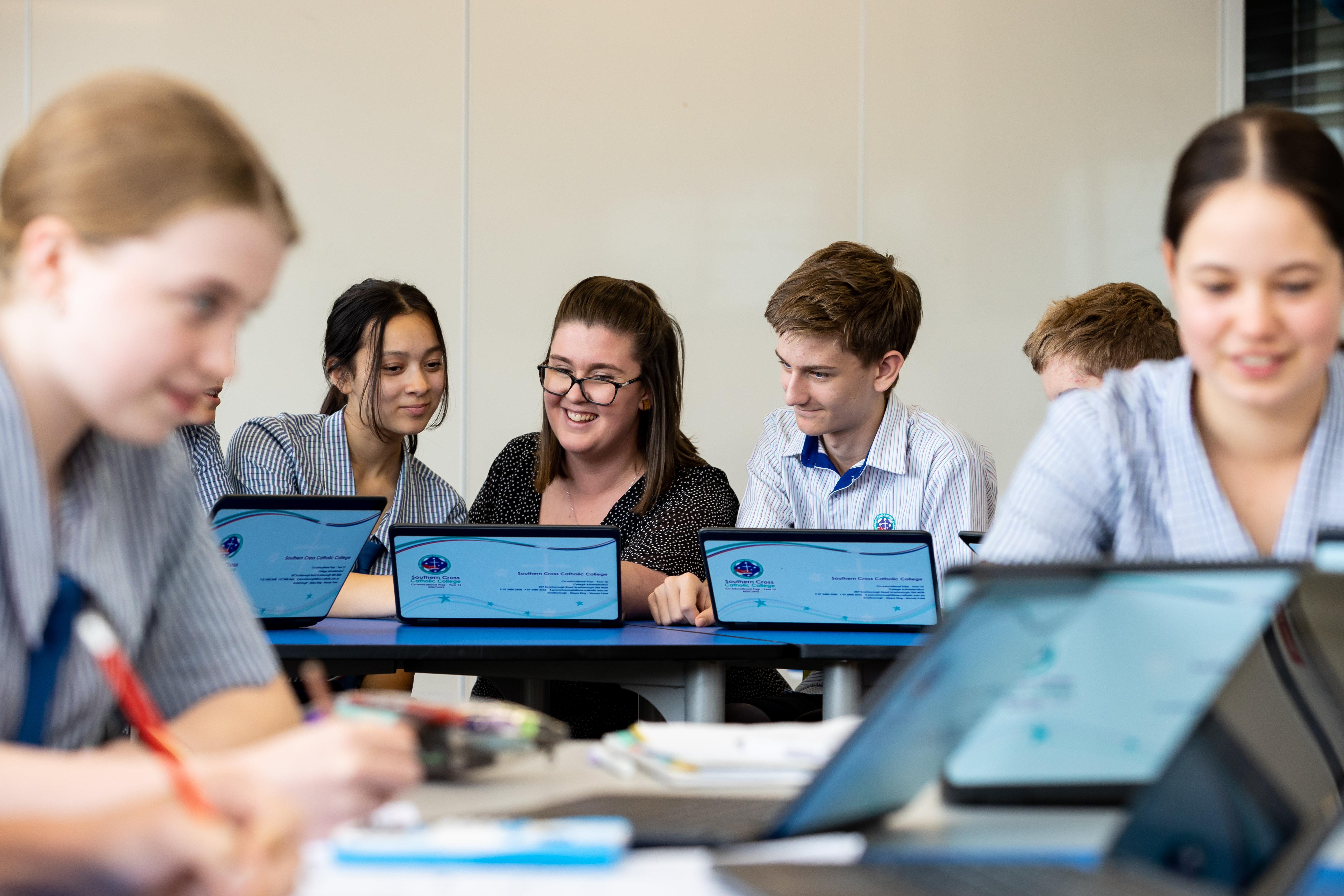 Students and staff member working on laptops